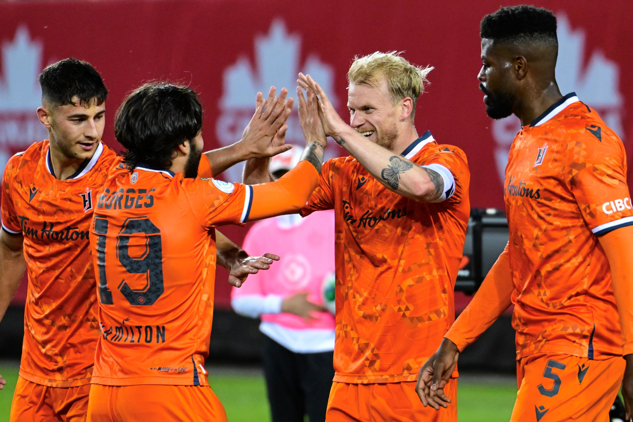 People high fiving after they join a sports team.