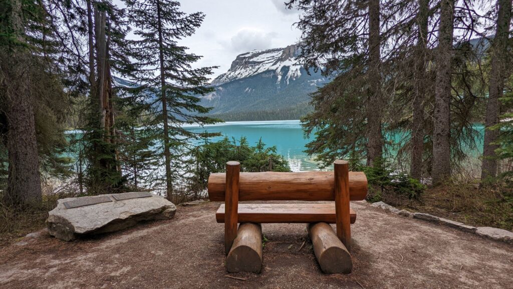 An image of a wooden bench in front of a lake with mountains in the background. What to do in Banff