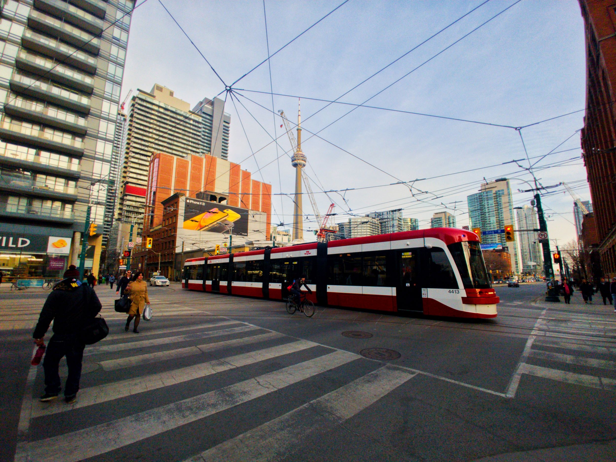Photo of a streetcard that uses the Presto card in Toronto in front of the CN tower.