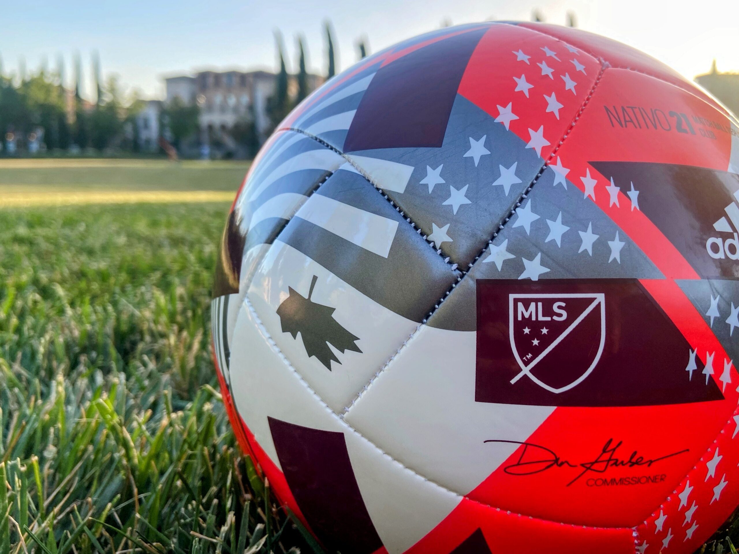 Photo of a red and white soccer ball with the logo for major league soccer on it.