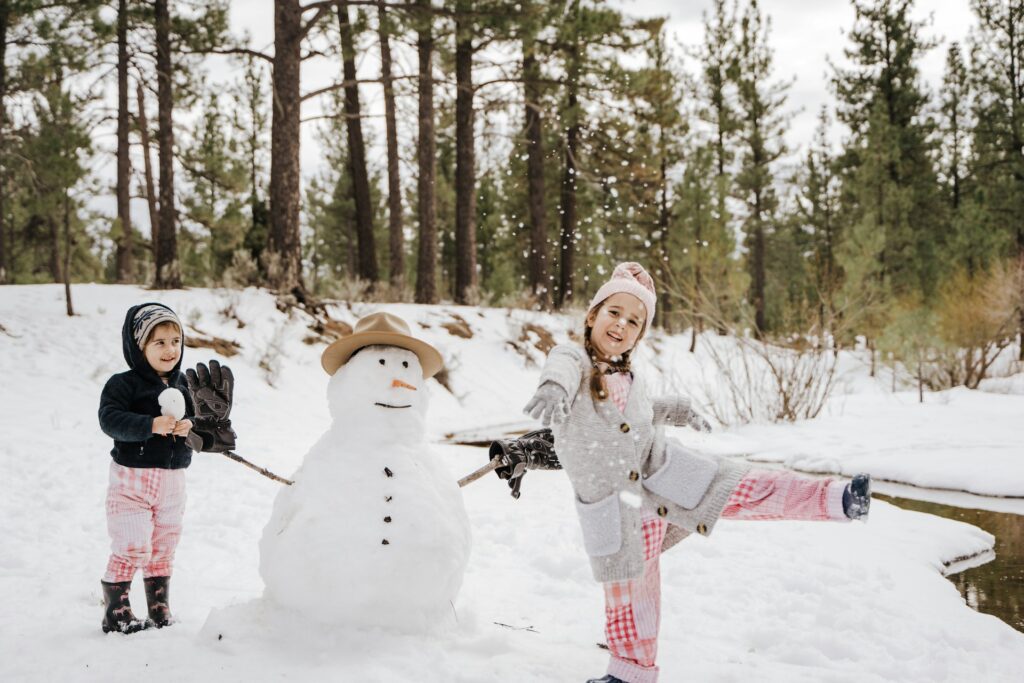 Children playing in the snow and building a snowman