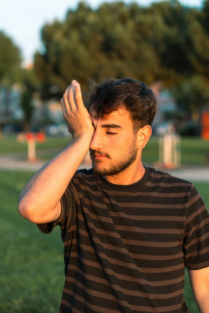 Person touching their itchy eyes due to seasonal allergies.