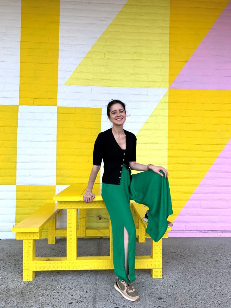 Canoo member sitting on a yellow picnic table.
