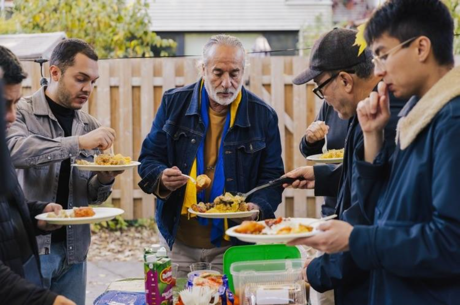 Still from Citizen Minutes documentary Hommes-Relais of several men eating food together.